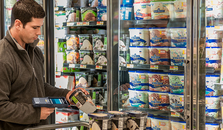 A man scanning the barcode of a carton of ice cream.